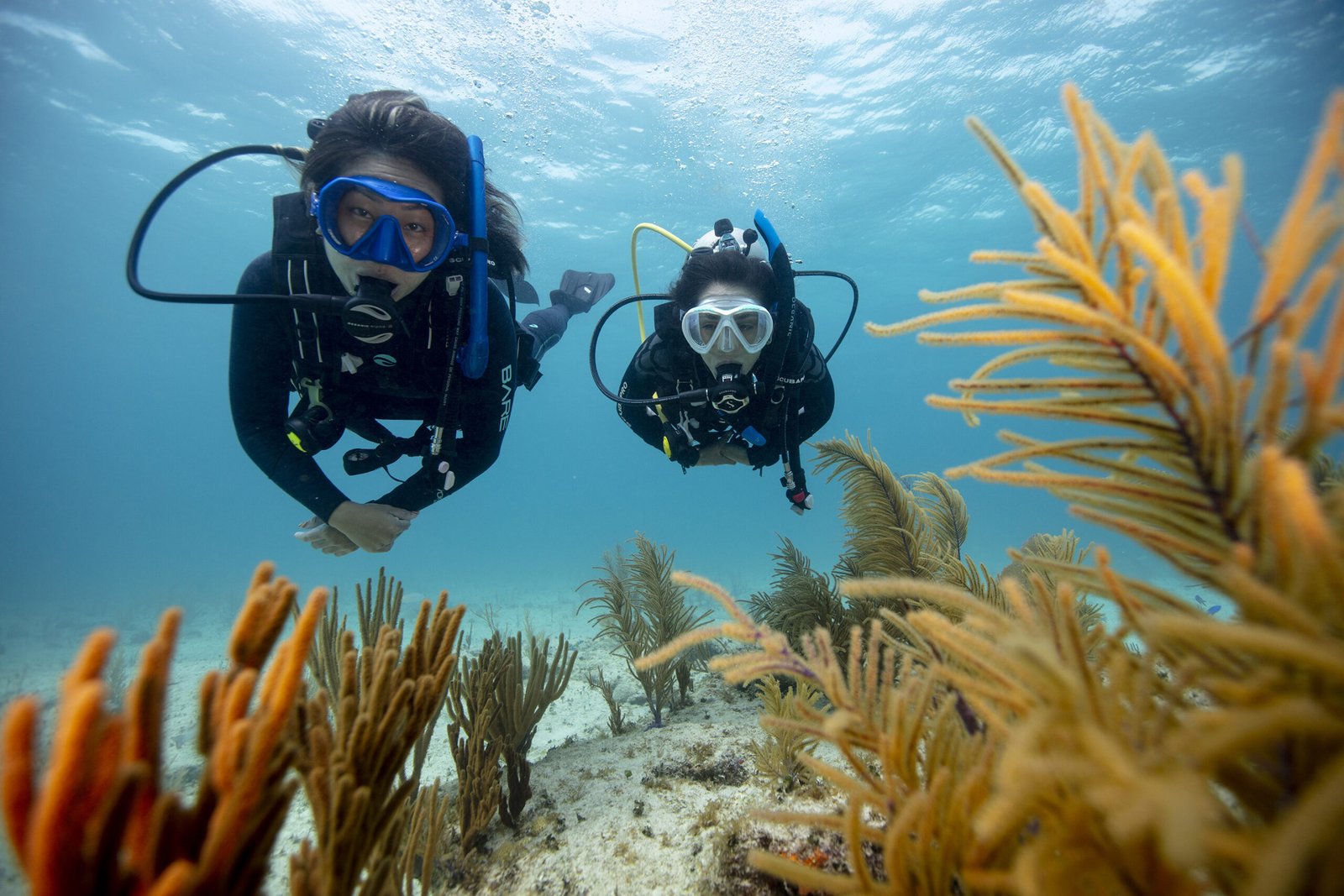 DYVUM Discover Scuba Diving students breathing underwater for the first time with instructor